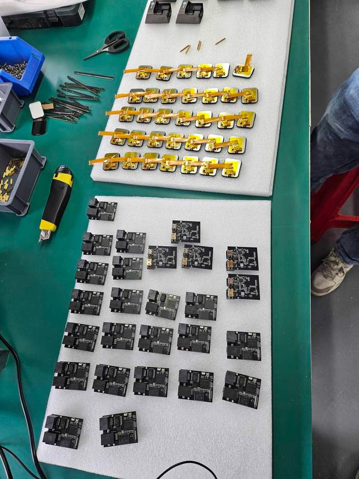 Pre-production JetKVM units arranged on trays before assembly.
