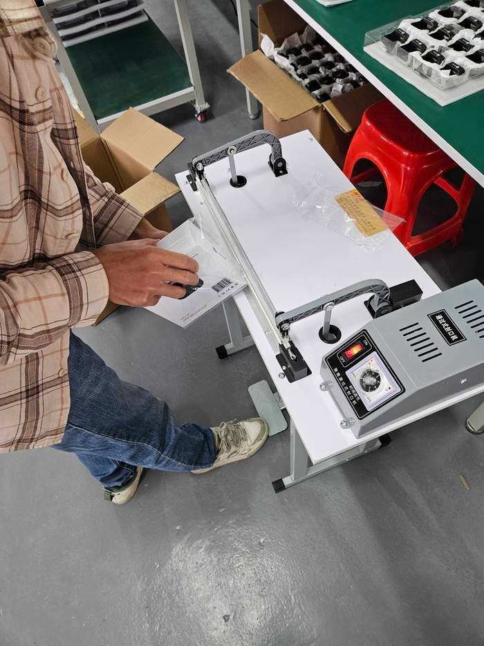 JetKVM packages being wrapped in plastic at the packaging line.